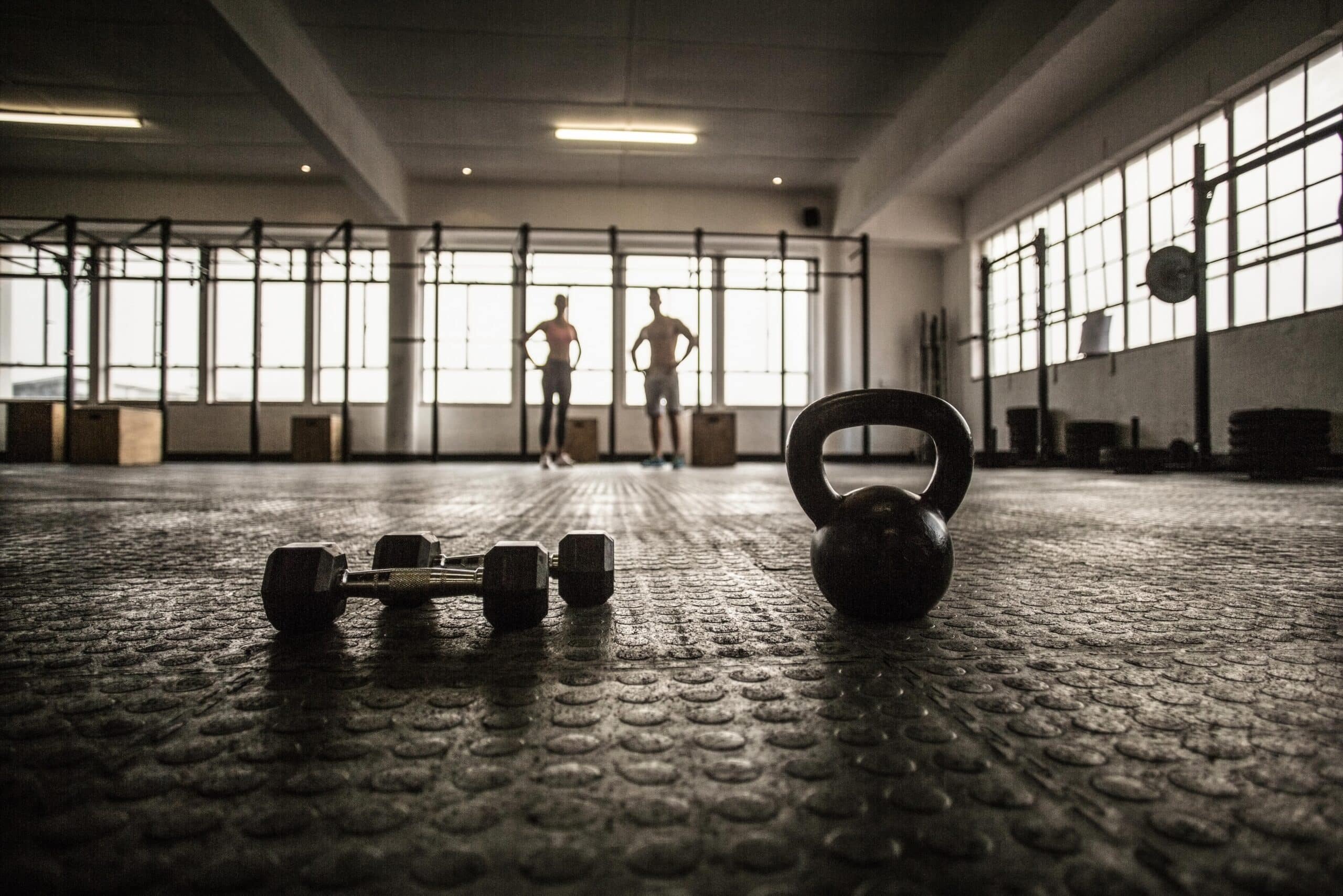 Two fit people on the background in crossfit gym